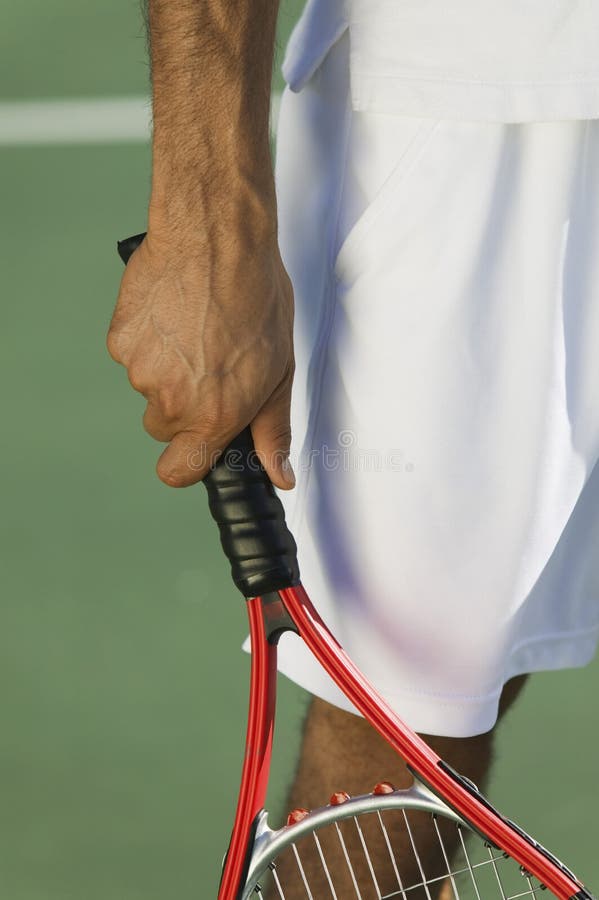 Caucasian Tennis Player in white tennis outfit holding red tennis racket. Caucasian Tennis Player in white tennis outfit holding red tennis racket