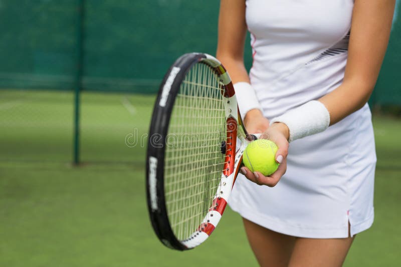 Tennis player holding racket and ball in hands