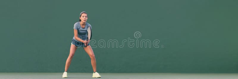 Tennis player woman ready to play in standing position. Female athlete waiting for serve on panoramic green background header banner. Challenge and concentration in competition.