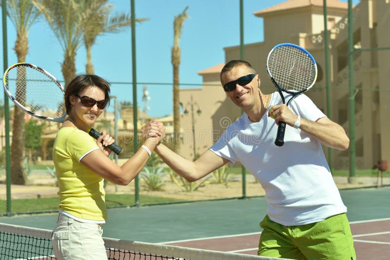 Tennis players standing near net on court