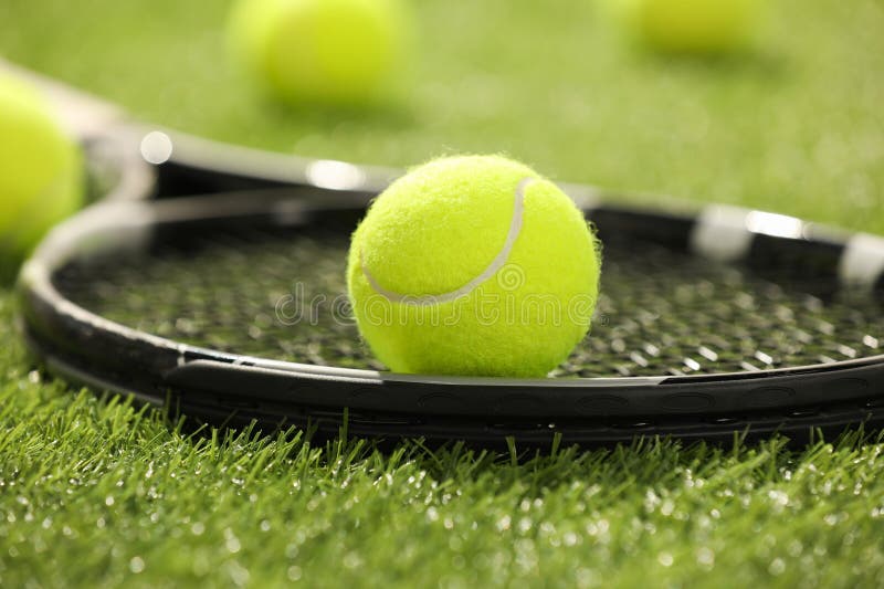 Tennis racket and ball on green artificial grass, closeup royalty free stock photo