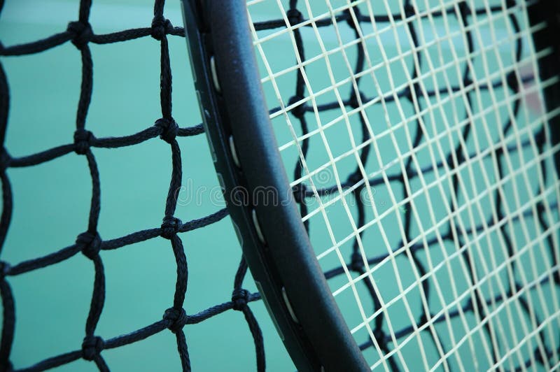 Closeup of a tennis racket resting against the net. Closeup of a tennis racket resting against the net