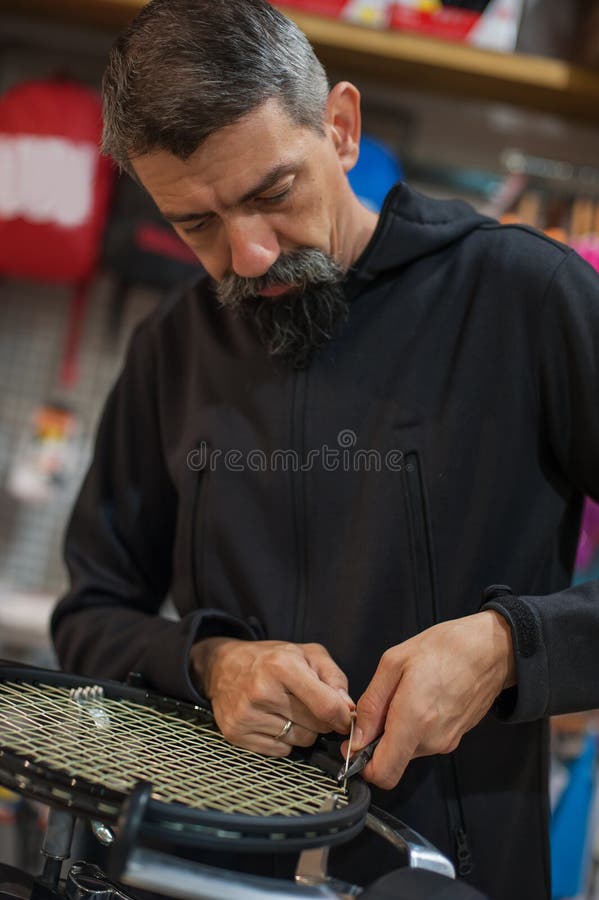 Tennis Stringer Tying Knots and Cutting String with Pliers Stock Image