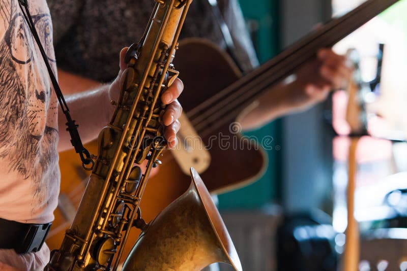 Tenorsaxofonspelaren spelar en jazz solo i en bar fotografering för bildbyråer Tenorsaxofonspelaren spelar en jazz solo i en bar fotografering för bildbyråer