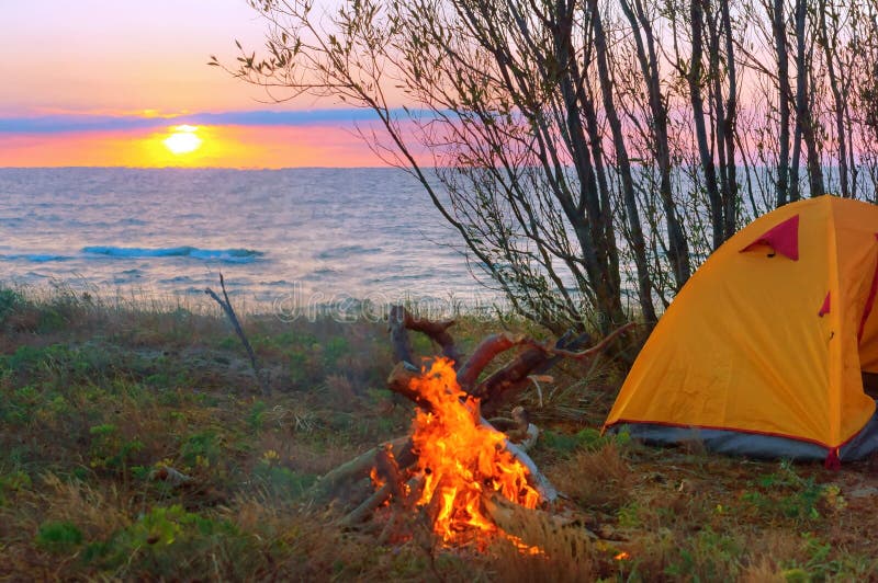 Tent en brand bij zonsondergang op het overzees, toeristentent op het strand royalty-vrije stock foto's Tent en brand bij zonsondergang op het overzees, toeristentent op het strand royalty-vrije stock foto's