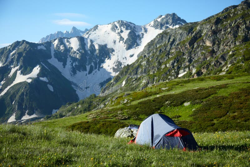 Tent on meadow in the high mountains