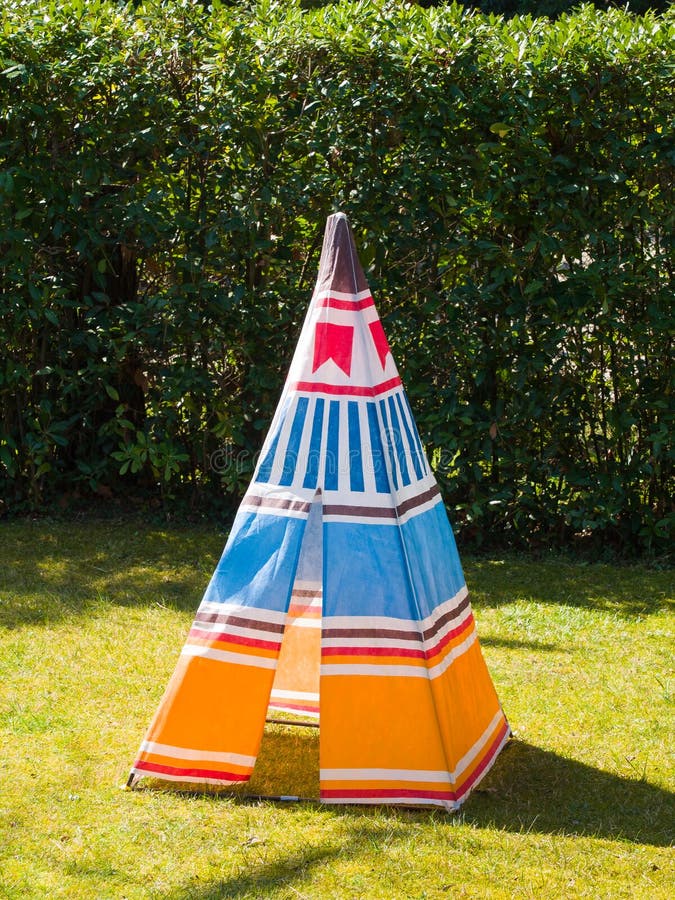 Tente colorée de tipi de jouet du ` s d'enfant sur l'herbe photo libre de droits Tente colorée de tipi de jouet du ` s d'enfant sur l'herbe photo libre de droits