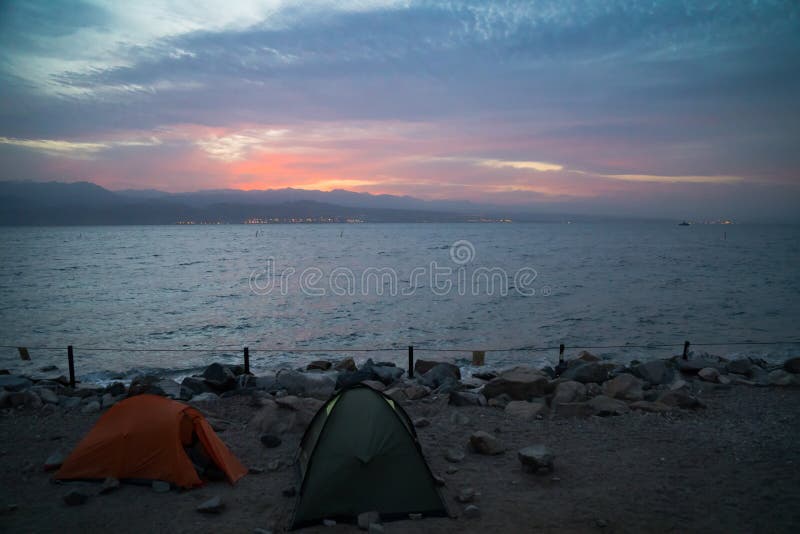 Tente verte et orange sur la plage plain. Lever de soleil sur la côte morte. Camper sur le rivage images libres de droits