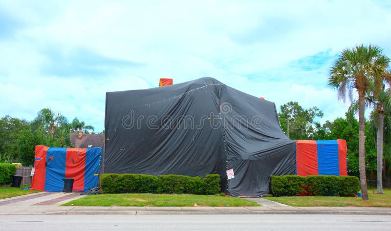 Tented large two story house that is being treated to kill termites and other bugs with structural fumigation royalty free stock image Tented large two story house that is being treated to kill termites and other bugs with structural fumigation royalty free stock image