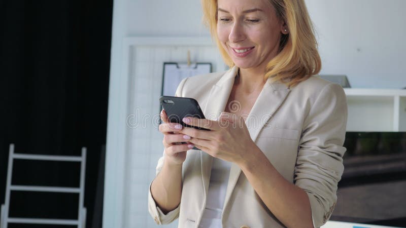 Tenuta e messaggio adulti dell'imprenditore su cellulare fotografia stock Tenuta e messaggio adulti dell'imprenditore su cellulare fotografia stock