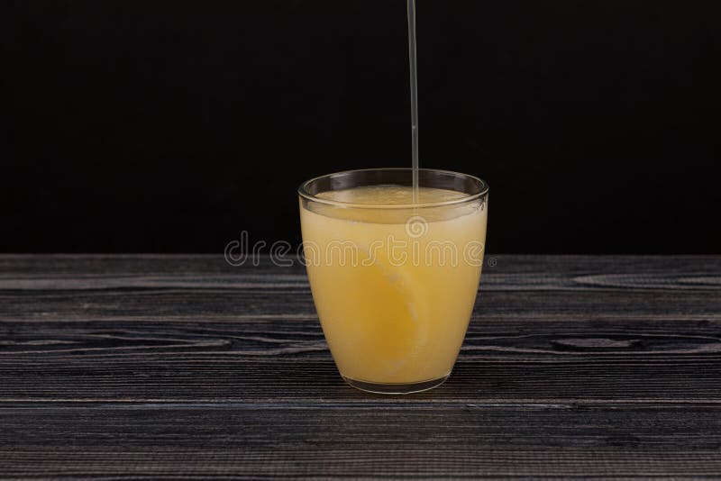 Tepache - Popular mexican fermented pineapple drink.  Chilled drink poured into glass. Dark background, copy space