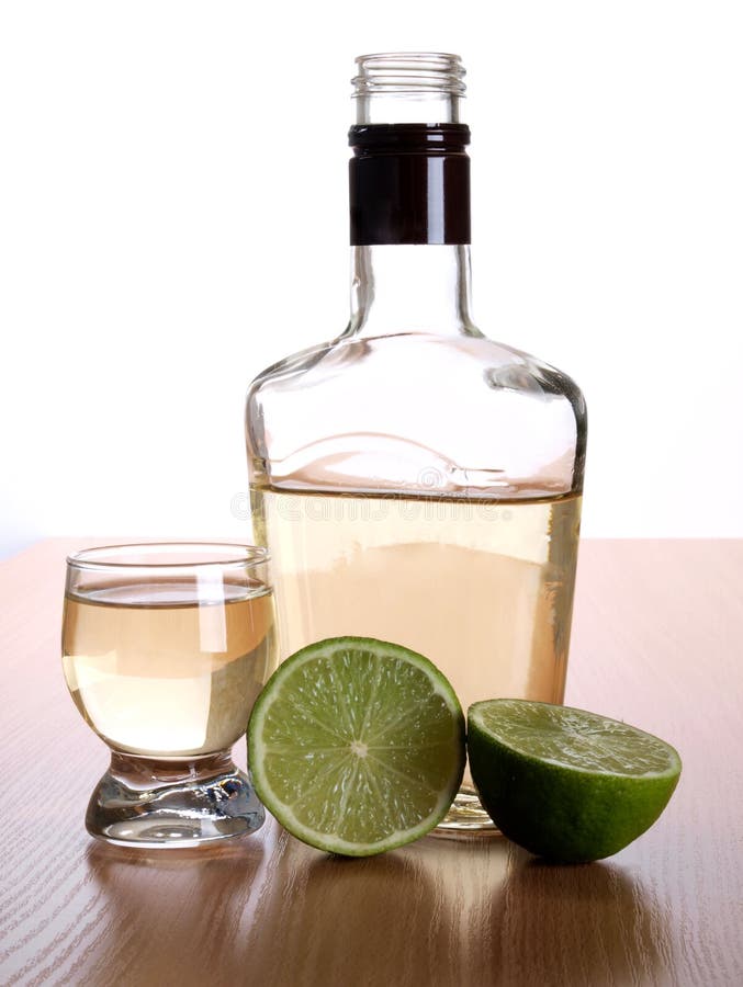 Tequila cup and bottle on wood