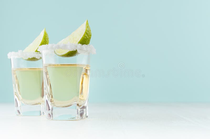 Tequila mexicaine d'or de boissons d'alcool avec la chaux de tranche, sel sur le bord dans la boisson tir? e sur le fond de couleu photo libre de droits