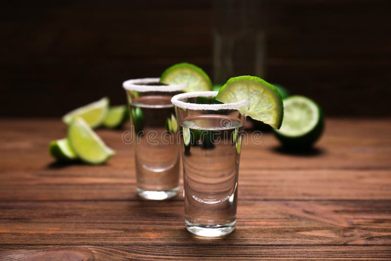 Tequilaskott med saftiga limefruktskivor och saltar royaltyfri bild Tequilaskott med saftiga limefruktskivor och saltar royaltyfri bild