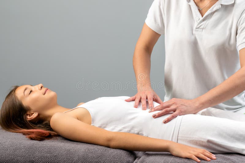 Terapeuta que hace masaje del abdomen en niña fotografía de archivo libre de regalías Terapeuta que hace masaje del abdomen en niña fotografía de archivo libre de regalías