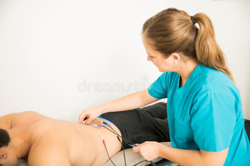 TerapeutPositioning Electrodes On kund för lägre tillbaka Musc royaltyfria foton TerapeutPositioning Electrodes On kund för lägre tillbaka Musc royaltyfria foton