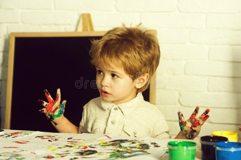 Art therapy. Drawing as a treatment for frustration. The boy draws his fingers. Child with paints. Art therapy. Drawing as a treatment for frustration. The boy draws his fingers. Child with paints