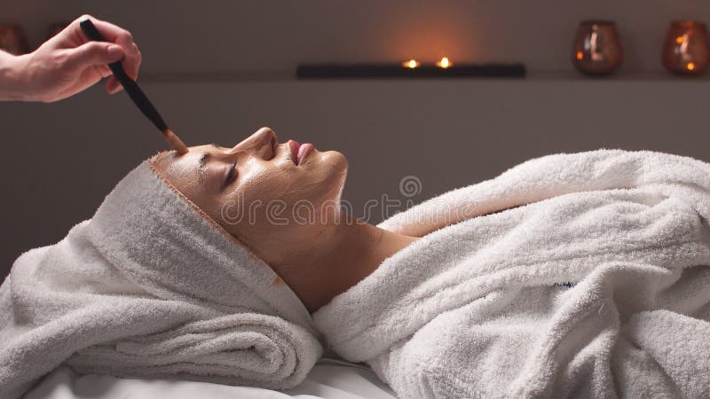 Terapia spa dla młodej kobiety przyjmującej maskę twarzy w salonie piękności obrazy royalty free Terapia spa dla młodej kobiety przyjmującej maskę twarzy w salonie piękności obrazy royalty free