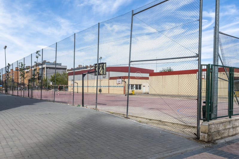 A sports area with basketball courts, soccer fields seven with a high metal fence. A sports area with basketball courts, soccer fields seven with a high metal fence