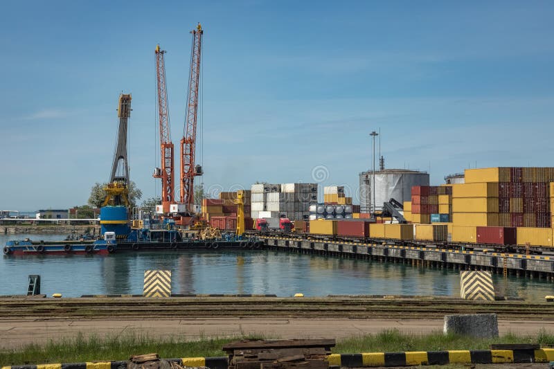 Terminal de port maritim cu macarale roșii stive de containere colorate clădiri de porturi royalty free stock image