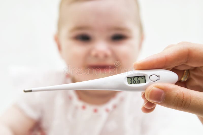 Termómetro para medir la temperatura de un niño enfermo foto de archivo Termómetro para medir la temperatura de un niño enfermo foto de archivo
