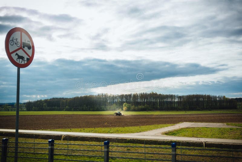 Terra di coltivazione del trattore in primavera, segno del trattore, cavallo e b immagini stock libere da diritti Terra di coltivazione del trattore in primavera, segno del trattore, cavallo e b immagini stock libere da diritti