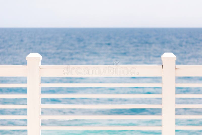 Terrace or balcony with wooden white fence, sea or ocean and clear sky, seascape background. Copyspace