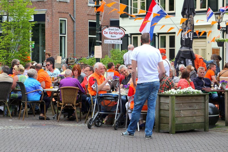 People have fun at a cosy terrace with Dutch flags, Kingsday (Koningsdag) in Baarn, Netherlands royalty free stock photos People have fun at a cosy terrace with Dutch flags, Kingsday (Koningsdag) in Baarn, Netherlands royalty free stock photos