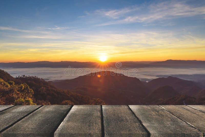 Terraza de madera con la opinión de perspectiva sobre las colinas de la montaña y los wi de la niebla