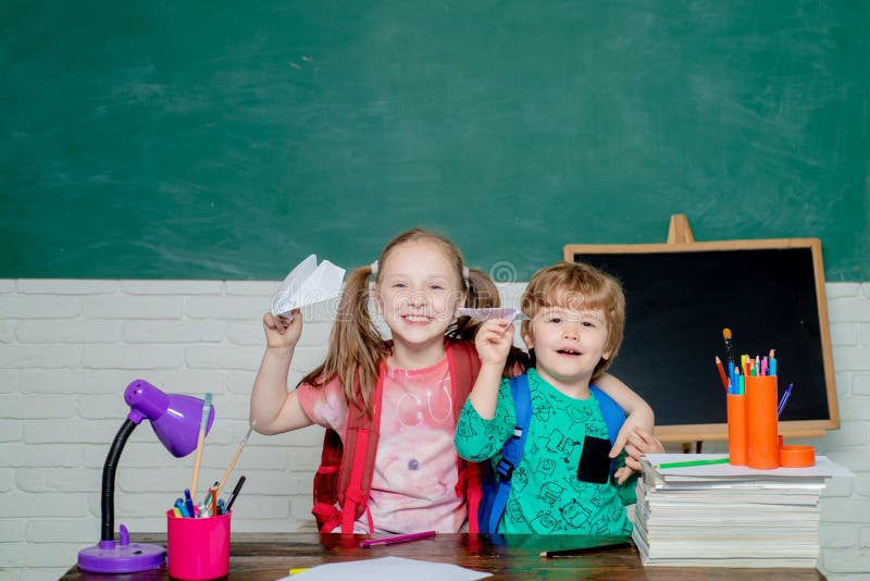 Terug naar School Leuk weinig peuterjong geitjejongen met Weinig spel van het kindmeisje met document vliegtuig in een klaslokaal royalty-vrije stock foto's Terug naar School Leuk weinig peuterjong geitjejongen met Weinig spel van het kindmeisje met document vliegtuig in een klaslokaal royalty-vrije stock foto's
