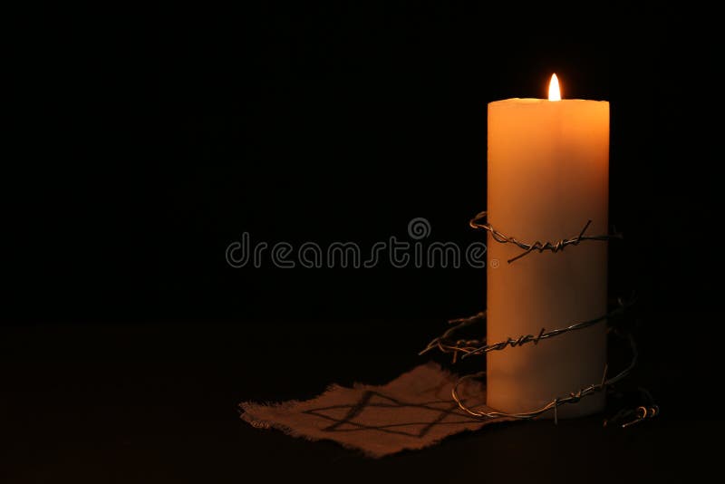 Fabric with star of David, barbed wire and burning candle on black background, space for text. Fabric with star of David, barbed wire and burning candle on black background, space for text.