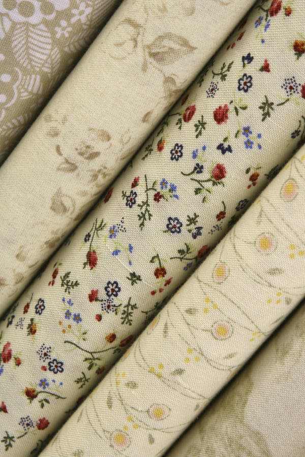 fabric bolts of quilt fabric in spring and neutral colors with flowers and floral designs. fabric bolts of quilt fabric in spring and neutral colors with flowers and floral designs