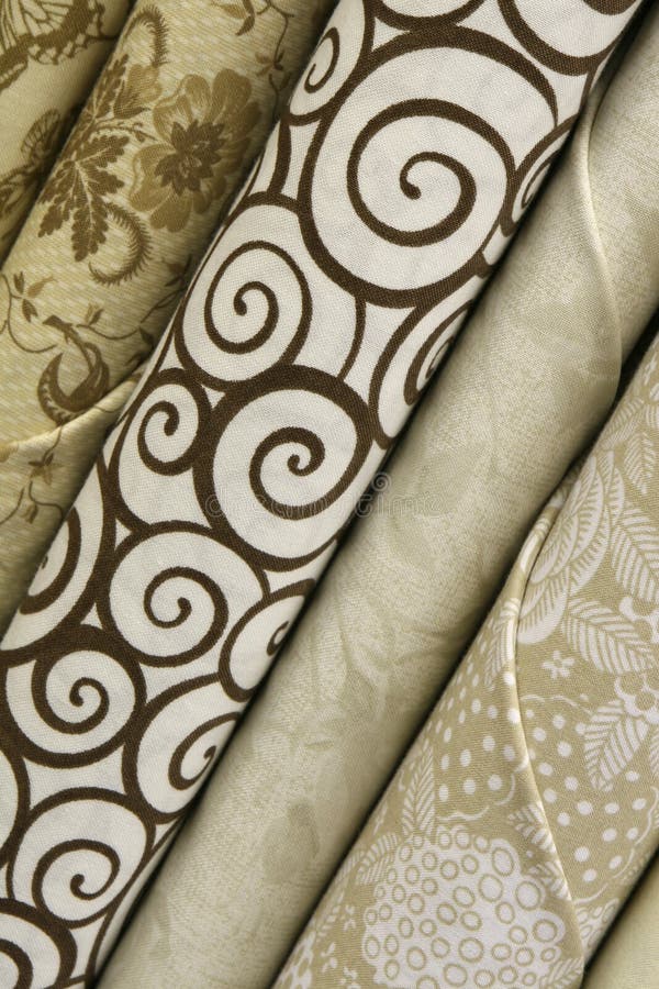 fabric bolts of neutral quilt fabric in white, brown and beige with abstract designs. fabric bolts of neutral quilt fabric in white, brown and beige with abstract designs