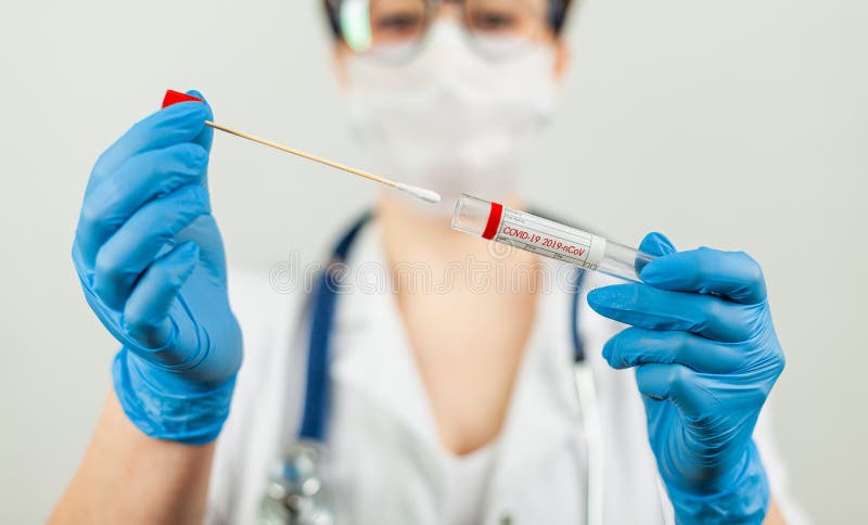 Test for coronavirus Covid-19. Female doctor or nurse doing lab analysis of a nasal swab in a hospital laboratory. Medical technologist holding a COVID-19 smear kit, wearing protective gloves from. Test for coronavirus Covid-19. Female doctor or nurse doing lab analysis of a nasal swab in a hospital laboratory. Medical technologist holding a COVID-19 smear kit, wearing protective gloves from