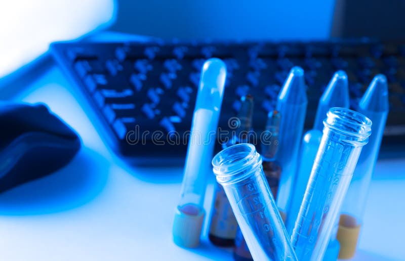 Test tubes in laboratory on table near computer keyboard and mouse stock images Test tubes in laboratory on table near computer keyboard and mouse stock images