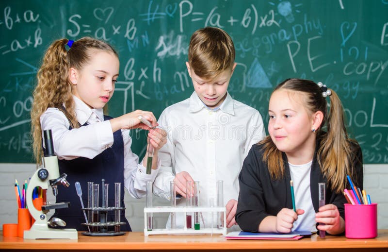 Test tubes with substances. Formal education. Girls and boy student conduct school experiment with liquids. School royalty free stock photos