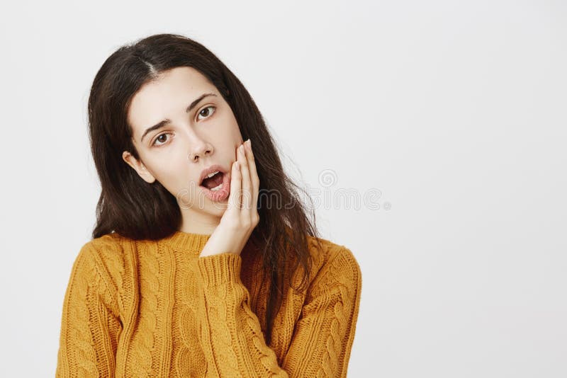 Testa di modello femminile mora annoiata e stanca della tenuta con la mano da non cadere addormentato, essendo andato ed iniziand immagini stock libere da diritti Testa di modello femminile mora annoiata e stanca della tenuta con la mano da non cadere addormentato, essendo andato ed iniziand immagini stock libere da diritti