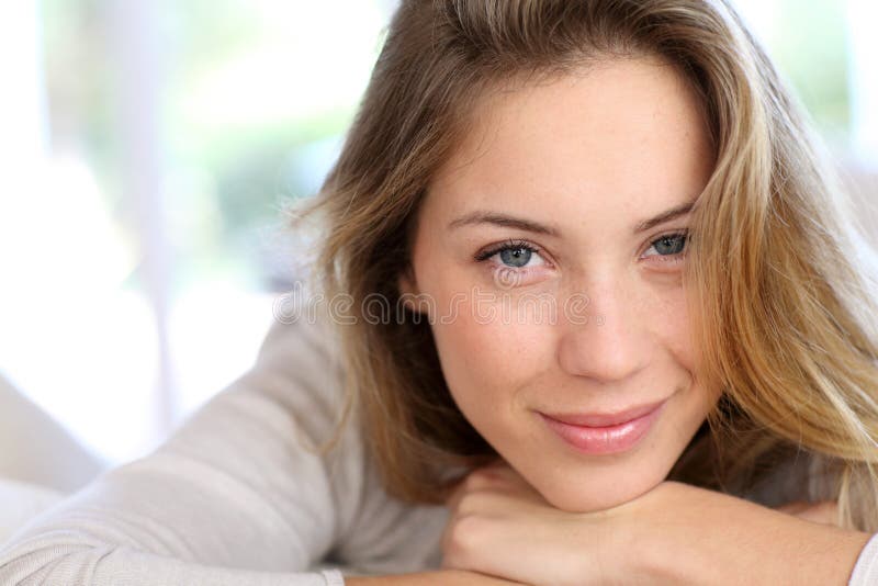 Testa pendente della bella giovane donna sulle sue mani fotografia stock Testa pendente della bella giovane donna sulle sue mani fotografia stock
