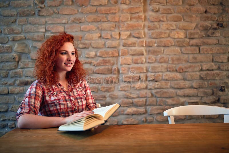 Testarossa femminile con il libro fotografie stock