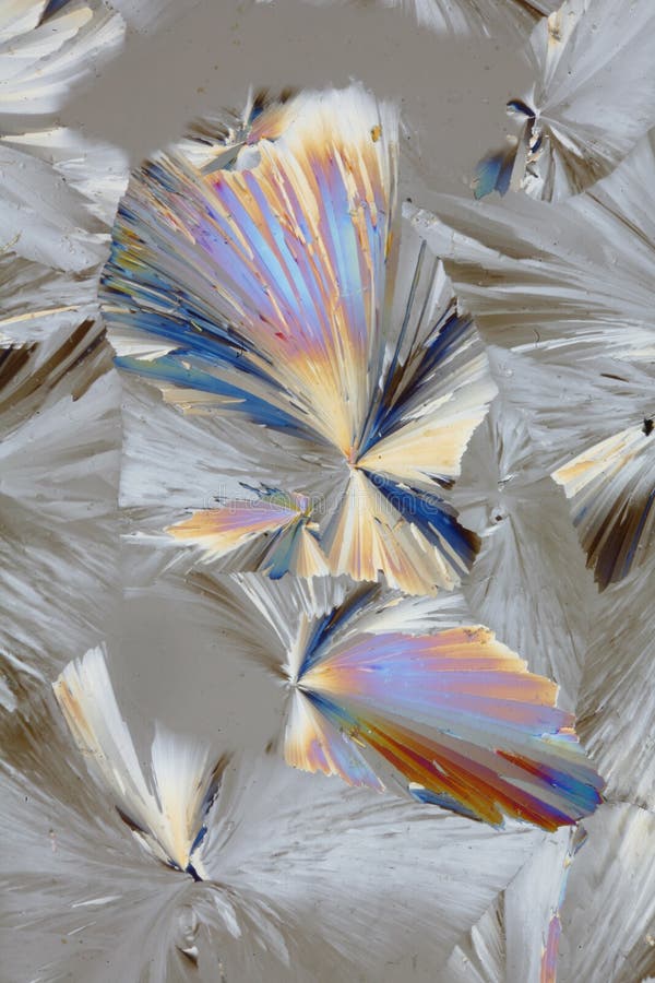 A view of bright, shiny and colorful patterns formed by citric acid crystals under polarized light. A view of bright, shiny and colorful patterns formed by citric acid crystals under polarized light.