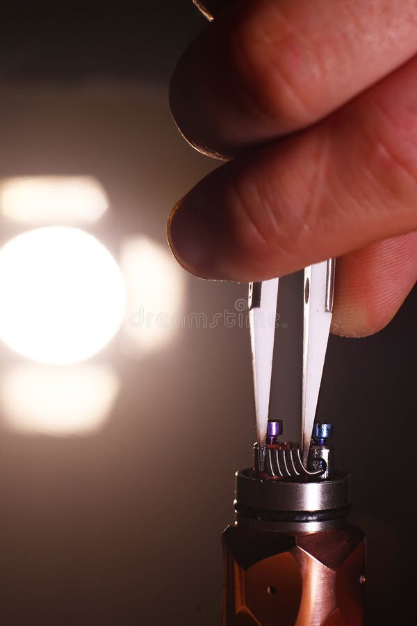 Teste a queimadura das bobinas duplas novas na base da plataforma dos atomizadores do cigarro eletrônico vaping, cena ascendente foto de stock royalty free Teste a queimadura das bobinas duplas novas na base da plataforma dos atomizadores do cigarro eletrônico vaping, cena ascendente foto de stock royalty free