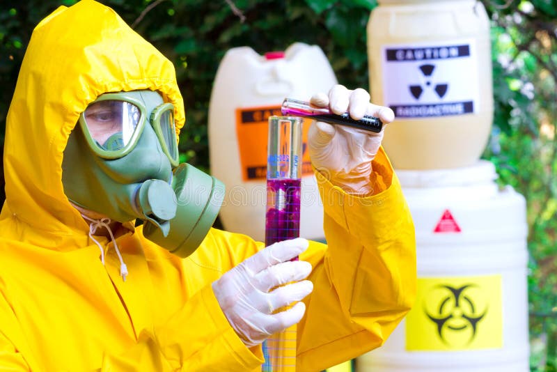 Testing of toxic substances. Chemist in protective clothing with gas mask examining toxic supsance,photography stock photography Testing of toxic substances. Chemist in protective clothing with gas mask examining toxic supsance,photography stock photography
