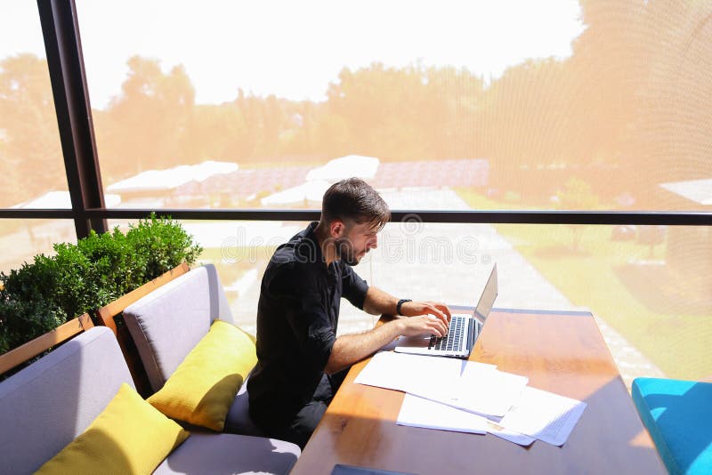Testo indipendente di riscrittura del copywriter sul computer portatile alla tavola del caffè immagini stock