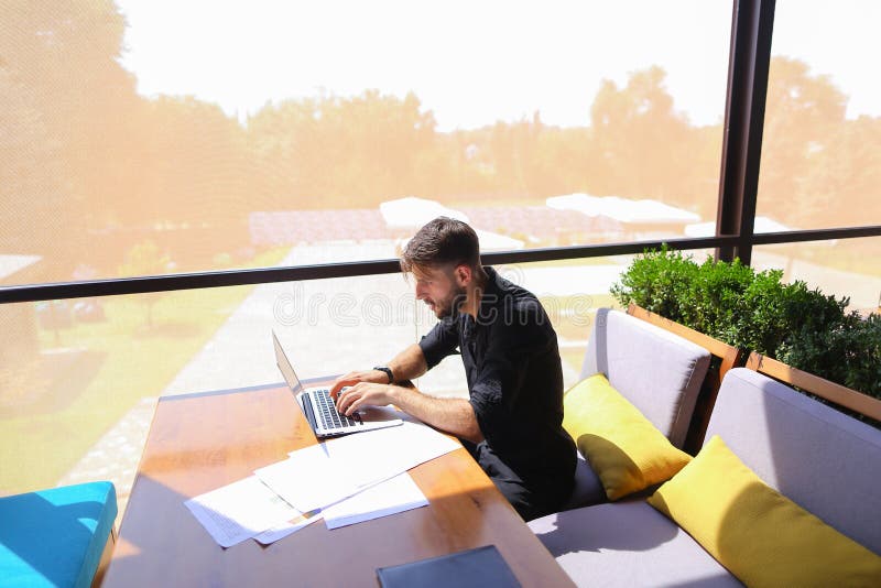 Testo indipendente di riscrittura del copywriter sul computer portatile alla tavola del caffè fotografia stock