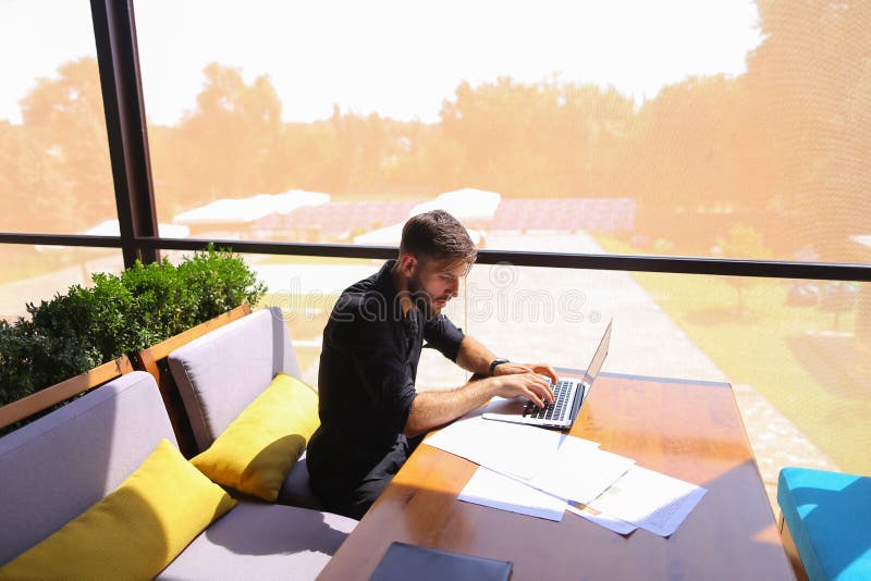 Testo indipendente di riscrittura del copywriter sul computer portatile alla tavola del caffè fotografia stock libera da diritti