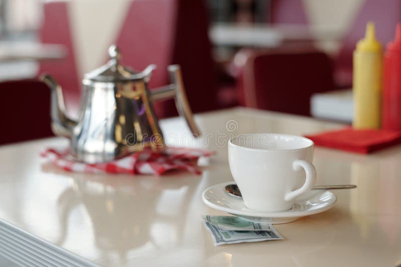 Tetera brillante y taza blanca en la mesa del restaurante fotos de archivo libres de regalías