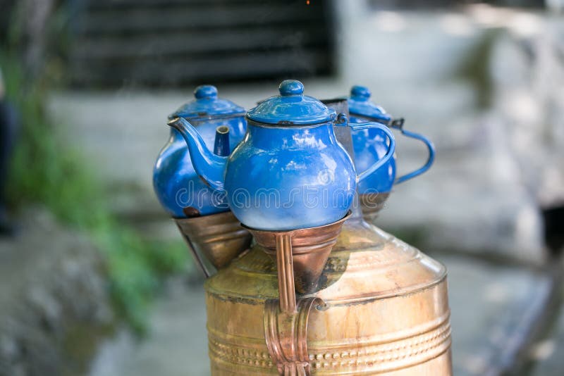 Teteras azules colocadas sobre el samovar de cobre imagen de archivo Teteras azules colocadas sobre el samovar de cobre imagen de archivo