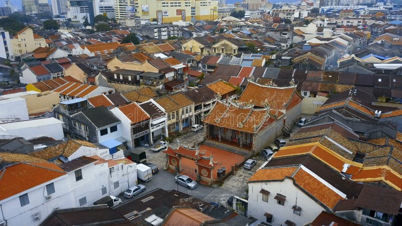 Tetti di mattonelle rosse nella parte storica della città di Georgetown sull'isola di Penang, Malesia Siluetta dell'uomo Cowering