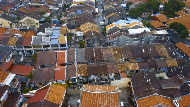 Tetti di mattonelle rosse nella parte storica della città di Georgetown sull'isola di Penang, Malesia Siluetta dell'uomo Cowering