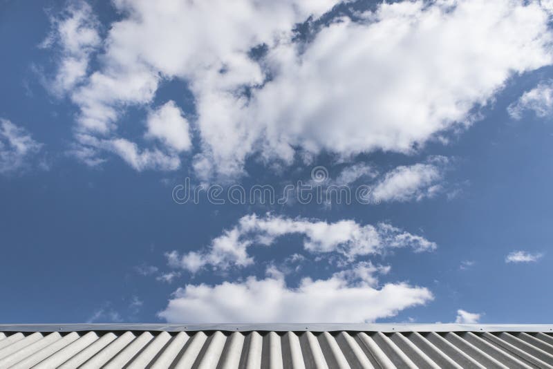 Tetto e cielo blu di ardesia ondulati grigi con le nuvole lanuginose bianche Bello cloudscape Giorno pieno di sole Priorit? bassa fotografia stock Tetto e cielo blu di ardesia ondulati grigi con le nuvole lanuginose bianche Bello cloudscape Giorno pieno di sole Priorit? bassa fotografia stock